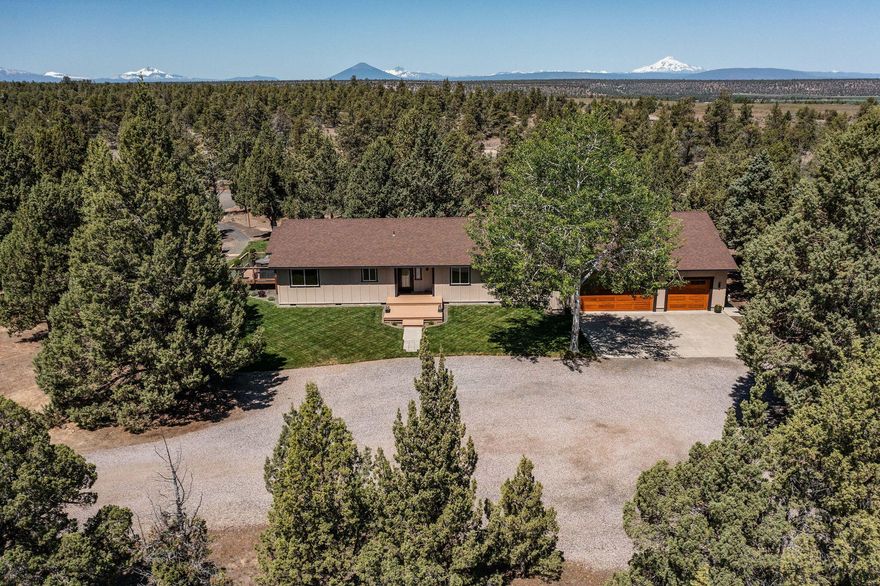 Own your own slice of Central Oregon paradise—this well appointed 3-bed, 2-bath home sits on 5.43 private acres bordering 850 acres of BLM land, offering stunning mountain views. The interior ftrs blue pine shiplap walls & modern fixtures that infuse the space w/rustic yet refined details inside & out. Vaulted ceilings, cozy gas burning fireplace w/stone surround & mantle. Lg Anderson picture windows flood the main living areas w/natural light. Open kitchen includes granite counters, ample cabinetry, SS appliances, & views of Mt. Jefferson. Spacious primary suite offers a walk-in closet, sliding barn door, bath w/granite counters & a step-in shower. 2 additional guest rooms share a full bath w/laundry. A flex space & bonus or family room provide added versatility. Enjoy the outdoors year-round w/your covered deck, hot tub area, outdoor shower, & groomed firepit space. 30x40 shop with 14' doors includes interior & exterior hookups—perfect for a powered RV retreat spot or campground!
