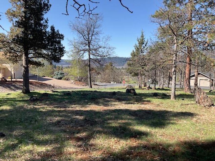 Level View Lot in the Running Y Resort!  Almost 1/2 acre of beautiful buildable land priced to sell. This corner lot overlooks the golf course and the Cascades to the south and sunsets to the west.  The elevation is above the street and then presents a large building plateau.  Mature trees offer shade and privacy.   Buy now and build later!