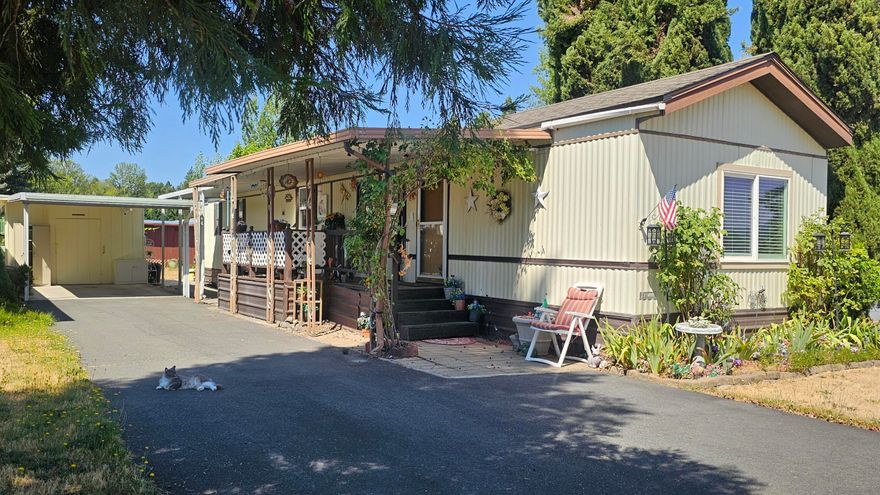 Nestled in a quiet 55+ community, this lovingly cared for 1985-built home offers comfort, charm, and convenience. This 2 bed/2 bath home boasts a spacious layout with inviting natural light.  Most of the home has updated, laminated flooring, as well as energy efficient windows, and an electric heat pump. The main living space has an attractive vaulted ceiling with fan. The functional kitchen features stainless steel appliances. The Master Suite includes a walk-in shower, as well as a walk-in closet. Outside, enjoy the pretty landscaping from your covered front porch! There is also an enclosed back porch, carport with shed, and separate workshop. The lower space rent includes water, sewer, and garbage!  With easy access to shopping and medical facilities, what are you waiting for?  Don't let this one get away!