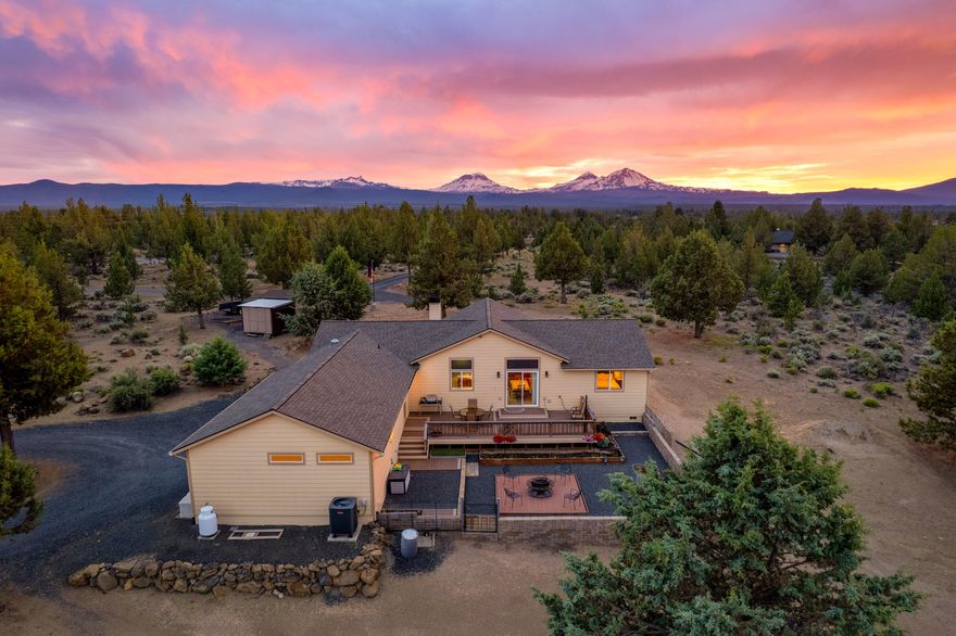 Enjoy peace, privacy, and Cascade Mountain Views from this nearly 10-acre property between Bend and Sisters. Appraised at $1.1M in June! Immaculately maintained by original owners, this single-level home offers an open floor plan with vaulted ceilings and a wall of windows framing the high desert landscape. The primary suite features dual
closets, double vanity, and separation from guest bedrooms. The kitchen shines with a
large island, Dacor 5-burner cooktop, soft-close cabinets, and new dishwasher. Entertain from the spacious back deck or paver patio, or unwind on the wraparound front porch. Cozy up by the wood stove and take in the sunsets. Oversized garage with epoxy floors and Level 2 EV charger; the enclosed third bay is temperature-controlled—ideal for office, storage, or workshop. Three 120 sq ft sheds with power, one finished with heat and a brick
patio. Detached carport, RV parking with hookups, and xeriscaped landscaping complete this serene rural retreat.