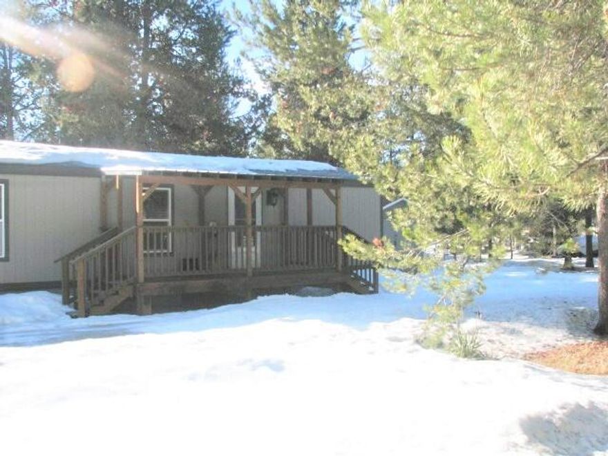 This cozy, move in ready home awaits you. Large covered front deck to enjoy the wildlife. There are four sheds and a chicken coop, a large 2-car garage with 220 amp service. This home is generator ready with exterior plug. The 320 sq ft composite deck in the back looks out to the large backyard. The interior of the home is freshly painted, has brand new vinyl, double paned windows and sliding door. Open kitchen living room has lots of light and an open feeling. The circular driveaway provides ease of access for all the toys you may want to bring with you. A quiet, peaceful home feels like country living but is just minutes from rivers, lakes and mountains. Shopping, medical facilities, post office, etc., are about 10 minutes away. Come and See!