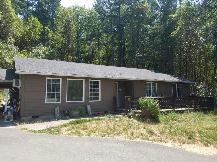 Enjoy living on acreage in the woods, while still remaining very close to the amenities and services of both Grants Pass and the city of Rogue River at this lovely mountain view setting. The home needs a little work (mostly cosmetic) but you will find this to be a diamond in the rough. This a rustic paradise with almost three acres set far back from the road with towering stands of Pine, Fir and Madrona in between. Water is available for irrigation through GPID.