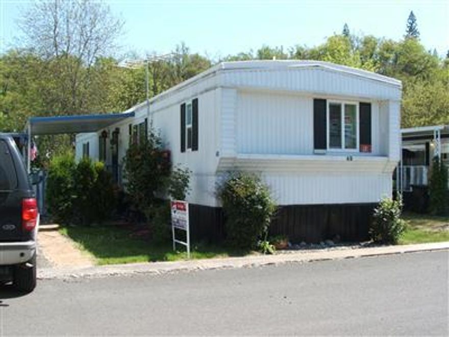 Lovely in park home with newer roof and new vinyl double paned windows. Light bright and airy home. Huge field behind home gives a wonderful country feel. Split floor plan- 1 bedroom and full bath at each end of home. Dining area in kitchen. New refrigerator. Tastefully painted inside and out. A must see, close to schools and shopping and Eagle Point Golf Course.