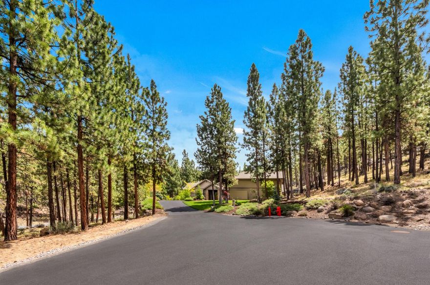 This beautifully constructed and meticulously maintained single level home located on 1.52 acres is the perfect mountain escape. Tucked away on the coveted NW side of Bend, Oregon near golf, The Deschutes River, Phil's Trail, Mt. Bachelor, The River Trail, schools, shopping and restaurants. As you approach the front door you will immediately notice the incredible pass through views to the private back patio and gorgeous waterfall. The 10-14 ft ceilings and walls of floor to ceiling windows offer warm indirect sunlight throughout the day. Floor to ceiling custom rock, wood burning fireplace in the spacious great room. The large island kitchen features hardwood floors, custom clear alder cabinets, stainless steel appliances and gorgeous slab counters. Owner's suite overlooks the exquisite landscaping & mature ponderosa pine trees. Huge garage with RV bay with a 14' door and over 31 feet deep, Room for 3 additional vehicles.  Private office, additional media room and your own private gym.