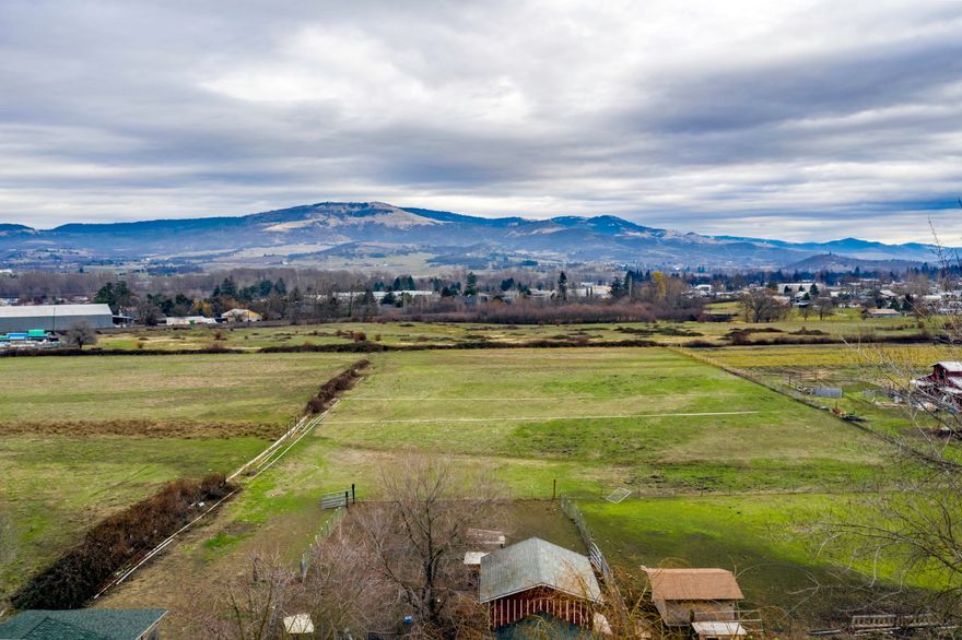 Country living in a very desirable area!  Located across the street from Voorhies Mansion/Edenvale Winery and within minutes of town. This incredible 4.3 acre property is the perfect mini farm and ready for gardening, horses, cows, sheep, pigs, goats and so much more! Irrigation rights with Medford Irrigation District. 4'' field irrigation pipes included. Incredible views with completely level land! Some of the recent updates in this charming farmhouse include new interior paint, new flooring throughout and updated bathroom, newer HVAC system! The large barn/shop is approximately 24x74 and a pig barn that is roughly 24x16. Household water is served by a well, natural gas to the property and city sewer! This is an opportunity you don't want to miss!