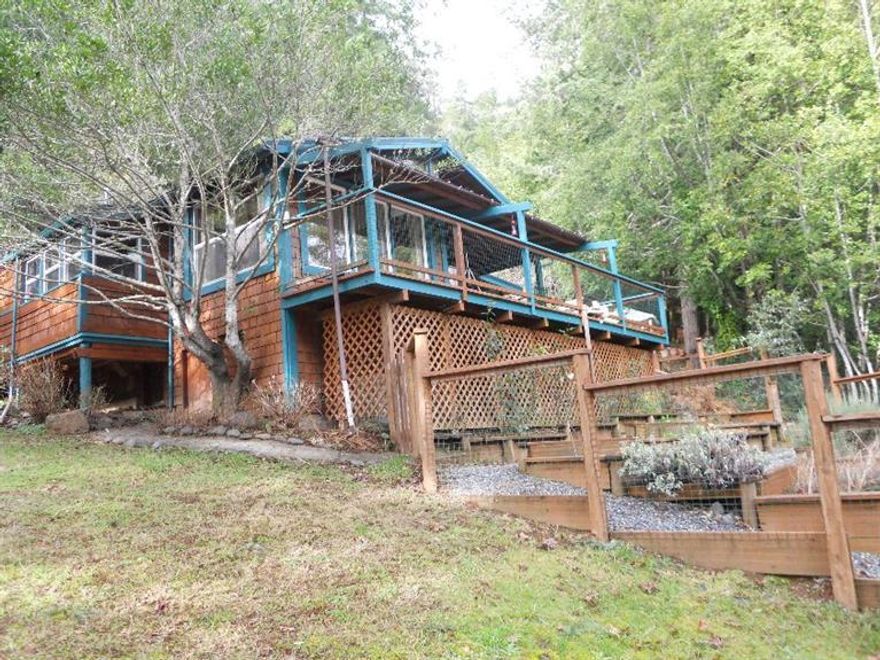 Wow! Rogue River front in Old Town Agness, Oregon! This is one of the best views and access of the river in Agness! This is an elegant remodel of historic Hog Eddy Cabin. The main house has two bedrooms and two baths with a formal dining room, great kitchen, utility room, pantry, a very good and certified wood stove, and the floors are made of solid southern yellow pine planks, a sitting room, wonderful deck overlooking the river and mountains. The guest quarters sleeps five with a bathroom and kitchen and again overlooks the river. There is a fish cleaning station outside with built in smoker for those Steelhead and salmon you catch! There is an RV garage or for your boat or outdoor recreational toys. In addition there are two different carports. There is a fantastic garden area (2) where lots of vegetables are grown and a raised herb garden below the house. Moorage below the house where you can swim and fish off your property! There is more, so contact for list.