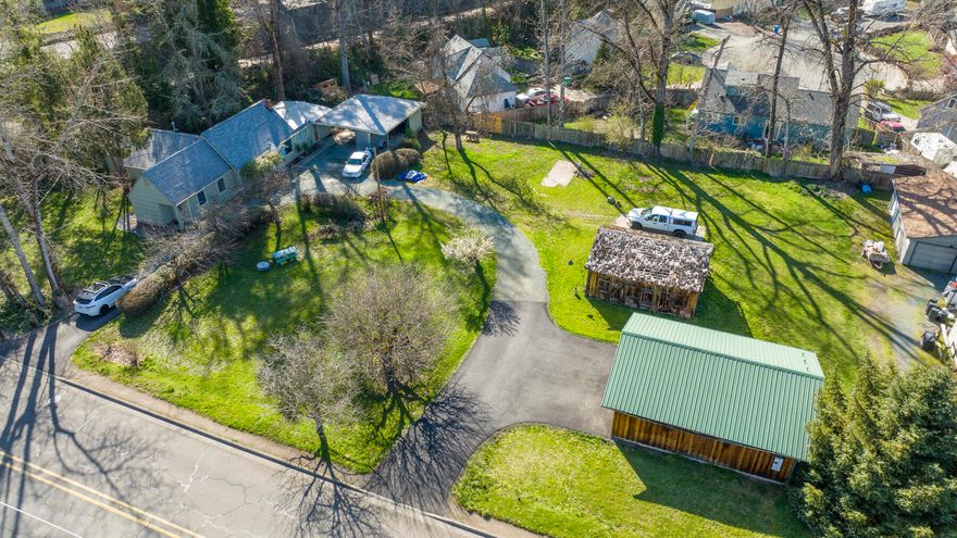 One of the last properties in this area that have one of the biggest lots.   This beautiful property has a newer two door shop garage with electrical and plumbing hookups ready.  Horseshoe driveway and parking for everything!  Old historic barn is on property for history.  Solid, well built home with updates throughout with 3 actual bedrooms on main floor and two bedrooms upstairs.   This property is on a well and has city sewer.   Park-like setting with a two car carport, patio, rv pad area, shaded areas and irrigation rights with GPID.  Excellent location within minutes to Grants Pass and shopping but rural feel.  Make your appointment to see this one customize to your liking. One of the biggest lots in the area that can be used to grow your own crops.  Get ready to view this one!  All photos and videos/tours are property of hommati.com/office/222