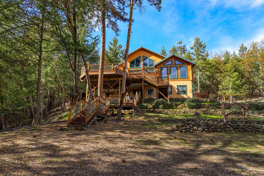63 Acres of seclusion and mountain views in Southern Oregon yet minutes to Jacksonville and Medford.  Amazing 3800+ sq ft handcrafted Handcrafted Montana fir home w/ 5 bedrooms and 4.5 baths. Great open floor plan with stone fireplace vaulted ceiling, kitchen, dining, living room for entertainment adjacent to the large multi level party deck w/ newer hot tub. 4 bdrms have their own full bthrms. Primary B/R has direct access to the hot tub and decks. Extra living dwnstrs with a large living / rec area, bedroom, FB, laundry and office all with private access. Newer high efficiency HVAC system. 1200 sq ft metal roofed shop/RV Garage w/ 200 amp service & a 2500 gal rainwater catch system. Multiple outbuildings incl. dog kennel/chicken coop, potting shed, & 16 x 24 insulated storage building w/ metal roof plus a refurbished, insulated hunters cabin &  400 ft zip line from the main house that drops near the cabin. Hiking, biking trails & roads networked throughout.