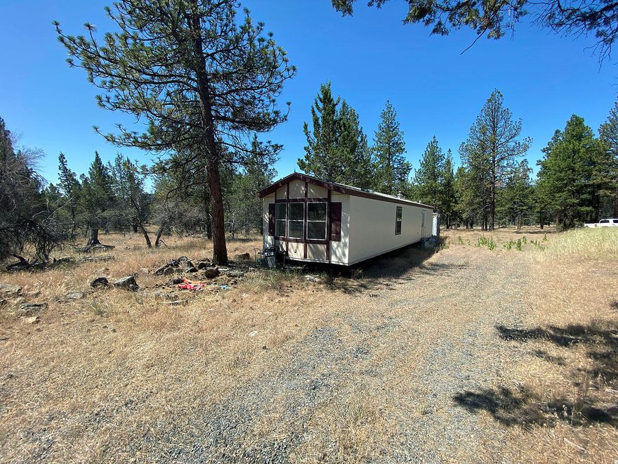 Rare Find of Improved Land in Bonanza!! Previous owner put in a lot of thought and time developing this 1.87 acre lot ready for the final touches! Even better, all existing material will go with the property. Improvements include an installed septic and a newly built 2011 pump house with a bathroom designed for a shower, sink, toilet and space for a stack-able washer and dryer. All necessary ditches have been dug up for piping. Drainage field has substantial property soil raised 2 ft. above grade for the septic system. Well is about 357 ft. deep. Utilities are about 150 ft. away but not necessary as property also includes a whole house gas generator with a new battery. Property comes with a 2003 manufactured home on wheels with all appliances included as well as a furnace and 1 electric stove and 1 natural gas stove. You will also find 10x10 shed and a 20ft shipping container for extra storage and a diesel heavy duty tractor. Everything you need is here!