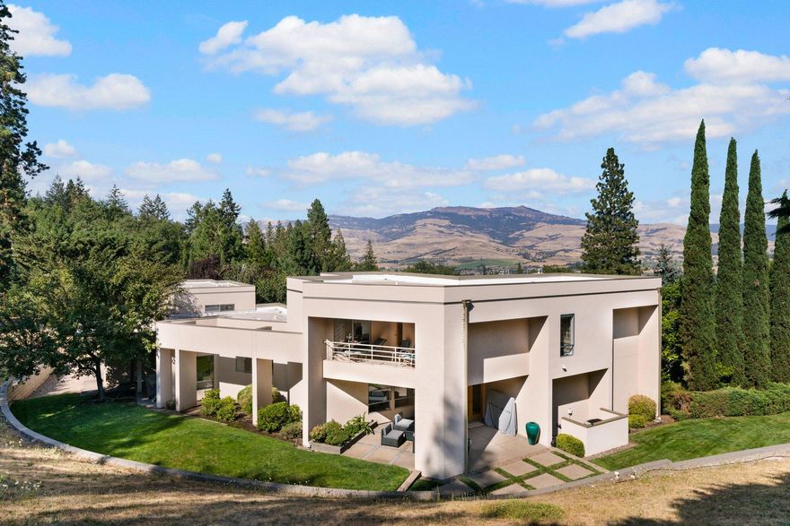 A magnificent Ashland estate is located above Lithia Park & the Plaza in a most desired location. Quality construction, exquisite attention to finishes and details, with extraordinary views of Grizzly Peak and Cascades. Large open living room has a gas fireplace and floor to ceiling windows. The primary bedroom is in its own complete wing. This includes a large primary bedroom, den/office and a master bathroom with a spa tub and glassed in shower and patio. The second wing has 2 bedrooms and 1 bathroom. The gourmet kitchen has a breakfast bar, an informal eating area which leads directly to the outdoor patio. The formal dining room can accommodate 6 or more guests. The kitchen has extensive cabinetry and counter space, high end stainless steel appliances and a gas stove. The main level has an extra room which has a queen sized Murphy bed and can be a den, TV, gym or whatever. This 1 acre gated estate gives you privacy while being close to the restaurants, theater and the park.