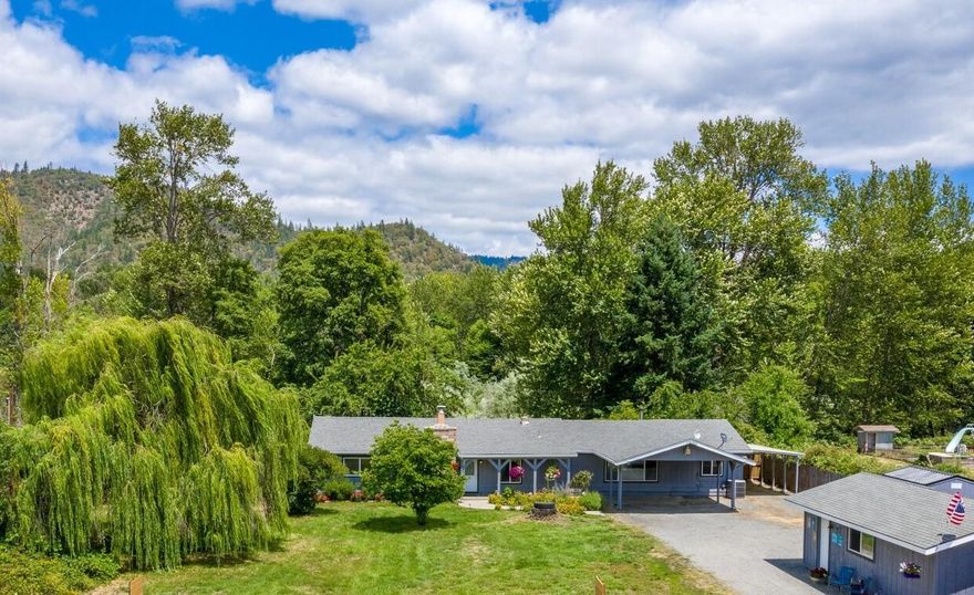 Absolutely gorgeous views from this beautifully landscaped 2+ acre level property bordering the Applegate River with updated 2100+ sf single level 3-bedroom home less than 15 minutes to town and hospital! The pictures tell it all....serene, peaceful & comfortable! Your recovery from this crazy COVID-19 world! Country kitchen with center island, pantry, double oven & open to spacious family room with cozy woodstove and access to covered patio with hot tub and magnificent mountain views. Deck overlooking the water! Huge formal dining room off living room with hickory hardwood floors & fireplace insert. Garden to your heart's content! Detached shop/garage. RV parking galore. Carports, Newer roof, windows, paint, flooring, etc. Massive cherry trees, weeping willow, dogwood & apple trees. Gated with 3-rail vinyl fence. Private, horse-friendly. Close in time to harvest tomatoes, corn, watermelon, peppers, etc.!