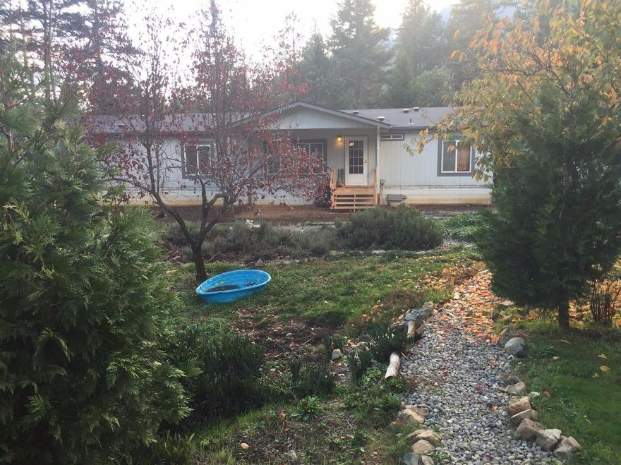 Lovely manufactured home sits on 5 level and rolling acres with a seasonal creek running through the property. Garden area. Fruit trees in orchard. 12x70 & 8x12 Shop/craft/storage bldgs. Finished detached 2 car garage. Fenced and cross fenced (property on other side of creek not fenced). $5,000 credit to buyer from seller towards new deck. Do not go out door of back craft room. Small deck area with no railing.