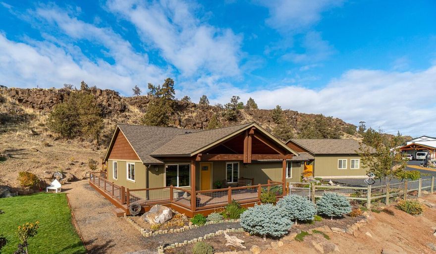 Stellar views of Smith Rock & beyond from your very own 1.53 acre homestead! Enjoy evenings on the wrap around deck & covered porch for year round Central Oregon sunrises. Vaulted great room layout w/attention to detail throughout. Tiled entry leads into main living w/ stylish carpeted area for gathering, ceiling fans & solar tubes for natural light. Kitchen ftrs central island w/breakfast bar seating, lg dining area, granite countertops, an abundance of cabinet & prep space, full height backsplash & double oven.  NEW SS appliances & corner wood burning fireplace. Primary bedroom ftrs carpet w/direct access onto back patio area. Walk in closet, full tiled shower w/dual shower heads & gorgeous built-in cabinetry. Guest rooms share a full luxury bath. Huge bonus room w/ cork flooring - perfect movie/game or exercise room! RV Parking, 1000+ sf garage/shop, fenced garden area w/raised beds, auto irrigation system & more. Minutes from amenities, the Pump House & Smith Rock State Park.