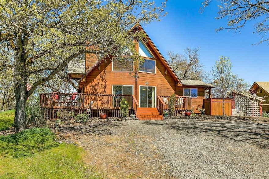 This beautiful Cedar Chalet Style Home sits on over 1.38 acres. Take advantage of this home's spectacular setting with a view overlooking the neighbor's huge pond, the mountains and open range. Enjoy the outdoor setting with several decks, patio, hot tub and beautiful water feature. With high vaulted ceilings, the first floor has an open floor plan with living room open to kitchen and dining. Kitchen has newer stove/range and refrigerator. There are 2 bedrooms and full bath and laundry on the main level. Upstairs to a spacious loft area for office of quiet space and the master suite. The property includes a 4 car garage and a large 42 x 30 ft garage/shop with 2 roll up doors. There also is a chicken coop with chickens included, garden area and good well with 2000 gallon holding tank. Home warranty included.