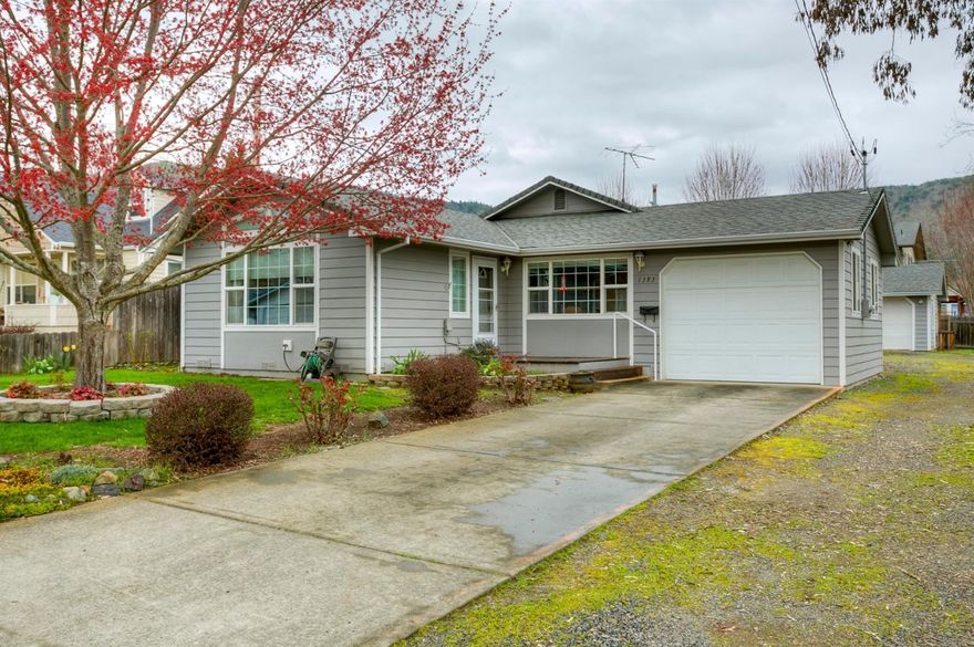 Very well kept home in NW Grants pass just one block South of Washington. Features 3 bedrooms and 2 full baths in the home and a half bath in the detached shop/garage. Kitchen features pantry and open to the dining area. Recessed lighting in the living room. This home was remodeled in 1987 and just last year new hardwood flooring was installed. The washer and dryer, were new in 2011. One car attached garage finished and a detached over sized garage with shop and half bath. A beautiful Covered deck surrounds almost two full sides of the home and an over sized front porch. Bedroom closets are deep and have wood sliding doors. Ceiling fan in bedroom.