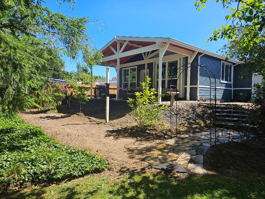 NEW HOME on land YOU OWN!  No space fees!  This is a new Golden West Home completed with a new garage and outdoor patio cover in 2024.  Built on a cement foundation using 2x6 floor joists 16'' 0.C. and 2x4 walls, 16'' O.C..   This home is as solid as they come.  Oversized windows in every room invites the great outdoors to come in.  9 foot ceilings throughout plus tray features makes this home light, airy,  spacious, well lit, and well ventilated.  The all electric kitchen, dining area, and living room are combined to give a great room feel.  As GREAT as the great room is, the attached patio area invites you to sit outside and enjoy the spruce, cedar, maple, dogwood, and magnolia trees - filled with golden finches that will delight any nature lover.  This three bedroom, 2 bath home is immaculate from the flooring to the top shingles; and will provide many years of maintenance free living.  Custom irrigated landscaping allows you extra time to walk to the beach or Walmart with a smile.