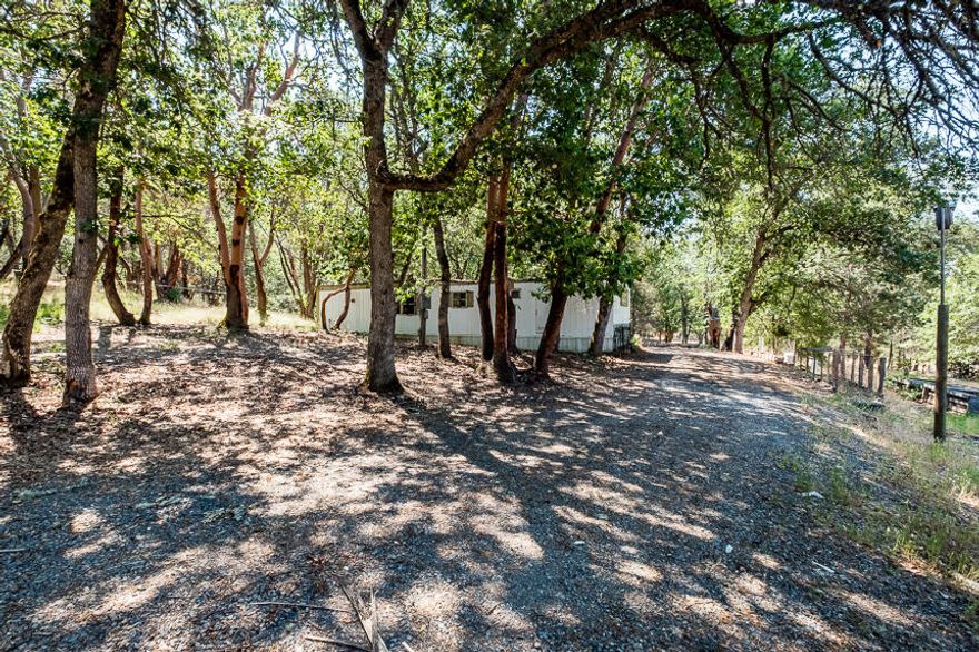 Great flat property with an old mobile home that is preserving the home site and ready for a new build. 6 gallon per minute well and 750 gallon Holding tank. Enjoy the peace & beauty of the southern Oregon countryside.. centrally between Jacksonville and Applegate area.