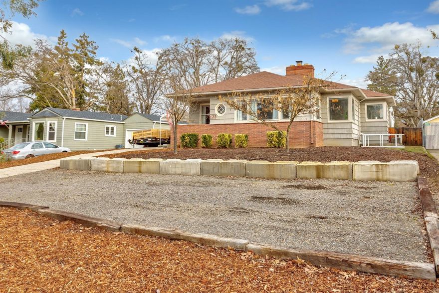 Desirable Old East Medford 1950's era cottage on large .23-acre lot! Covered front porch and exterior brick accents. Arched door way to spacious, open family room with fireplace and ceiling fan. Beautiful hardwood flooring throughout. Formal dining space with wainscoting and is open to living room. Kitchen offers granite counters, tile flooring, microwave hood, range/oven, refrigerator and dishwasher. Sunny breakfast nook off kitchen. Indoor laundry. Updated bathroom features double sinks and tub/shower. Fully fenced, manicured back yard with raised garden bed and shed. Covered back patio. Detached 2 car garage. Great off-street parking.