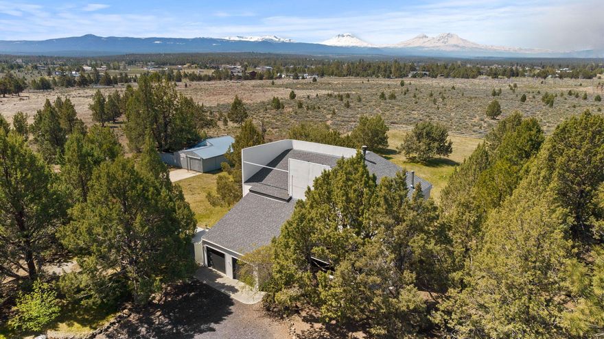 Located between Tumalo and Sisters, this Art Deco-inspired home sits on 6.19 acres with a barn, garden, and greenhouse—backed by stunning Cascade Mountain views and thoughtful landscaping. The 2,792 SF, 3-level home features 3 bedrooms and 2.5 baths. The main level includes a great room, breakfast nook, and a picture window that fills the space with natural light. Downstairs, enjoy a family room, private office, two bedrooms, a full bath, and access to a private patio. Roof replaced in 2020. Exterior painted in 2024
