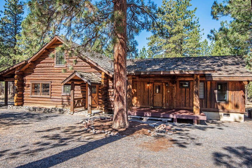 Cabin in the Woods! Located on 10 private acres bordering national forest, this 1,924 SF log home in Sisters, Oregon brings the outdoors in. Hand hewn logs insulate and impart a fresh woodsy scent.  2 fireplaces and heated tile floors provide warmth. The great room has a floor-to-ceiling stacked rock hearth surround quarried in Oregon. Open floor plan, vaulted wood ceilings, log posts & cross beams, & birch wood floors.  Updated kitchen includes granite countertops, breakfast bar, cherry cabinets, limestone floors, wine storage, plus stainless-steel appliances: refrigerator, 5-burner propane cooktop, oven, microwave, & dishwasher. The great room bookcase conceals a secret entrance to the main level sleeping quarters: 2 bedrooms and 2 updated baths on with hardwood and radiant heat tile floors.  Upstairs, the 388 SF carpeted loft/3rd bedroom overlooks the great room. 320 SF cabin has a rock hearth for a wood stove. 1,728 SF pole barn for parking, storage & animals. Direct trail access!