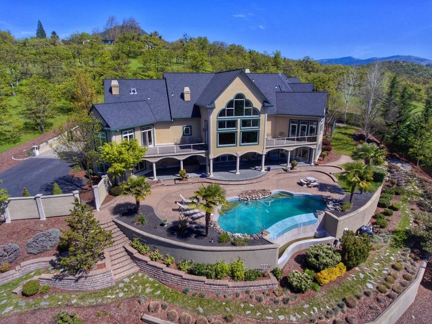 MOVE-IN READY! Custom elegant home offers spectacular architecture and design. Stunning views of the Rogue Valley and city lights. 4+ bedrooms, 7832 sq feet on a large .86 acre view lot with in-ground swimming pool & mature landscaping. Gated entry, 3 car attached garage, 4 car/RV detached garage with full hook up's. Soaring 28' ceilings in the entry, floor to ceiling windows overlooking the pool & valley, fireplace, maple & tile floors. Custom kitchen with large island, stainless steel appliances, wine re-fridge, tile floors & fireplace. Master suite on the main floor, Office with built-in's, Theater room, 12X18 Safe room, Exercise room, Entertainment room with 2nd full kitchen & tons of storage through out. Security system, 4 zone HVAC system, full house surround sound, custom lighting and so much more! Attention to detail through out.