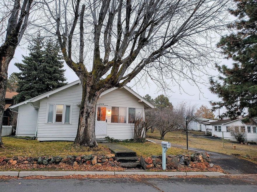 This charming home sits on almost 1/3 acre. it is accompanied by both apple and plum trees, along with a patio draped by hanging grapevines. The home has a large master bedroom with an air conditioner. Over the years this home has been well cared for. The bathroom is tiled. Wood floors throughout have been refinished. The front porch is enclosed and the basement has a working area that can be used as a shop plus a gas canning stove with dual sink, and a washer and dryer hook up. The kitchen has been updated; a second laundry room with a chute to the basement is located adjacent to the kitchen. Henderson park is located across the street.