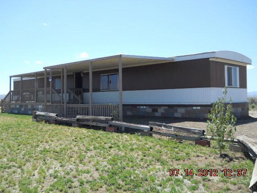 Nice 2 bedroom & 1 bath, new laminate flooring in bedrooms & living area for easy cleaning. Large front covered porch too. This home is on a block foundation & sits on about a third of an acre. In addition, there is a carport, nice storage shed, gravel drive and front yard with some landscaping. Mountain views in the distance, not far form the dunes for some recreation fun. Not to far from town, Golf, Park & Lake. Possible owner terms. Call to schedule an appointment today.