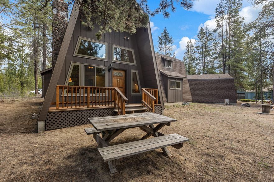Rare riverfront offering! Nestled amongst the mature pines of the Deschutes National Forest, this gorgeous A-frame home sits on nearly an acre w/ 150ft on the river! Min from world class fly fishing, hiking, Mt Bachelor & the high lakes. This exclusive community surrounds the Fall River hatchery & is the heart of Central Oregon recreation. The home itself ftrs two beds, two baths, plus a loft area. High ceilings, large windows, & light interiors set for a natural brightly lit interior throughout. Beautiful stone wood burning fireplace in the main living area. Kitchen ftrs an small central island, an abundance of cabinetry, wood flooring, large dining area, plus a wood burning stove! Primary bedroom is well sized w/ step in shower & vanity sink area. Additional bedroom & loft area share a second bath w/ clawfoot soaking tub! Loft ftrs mini-kitchenette w/ bar seating! Property ftrs woodshed, detached single car garage w/ mini kitchen, full bath + bunk area! Firepit outside + more!