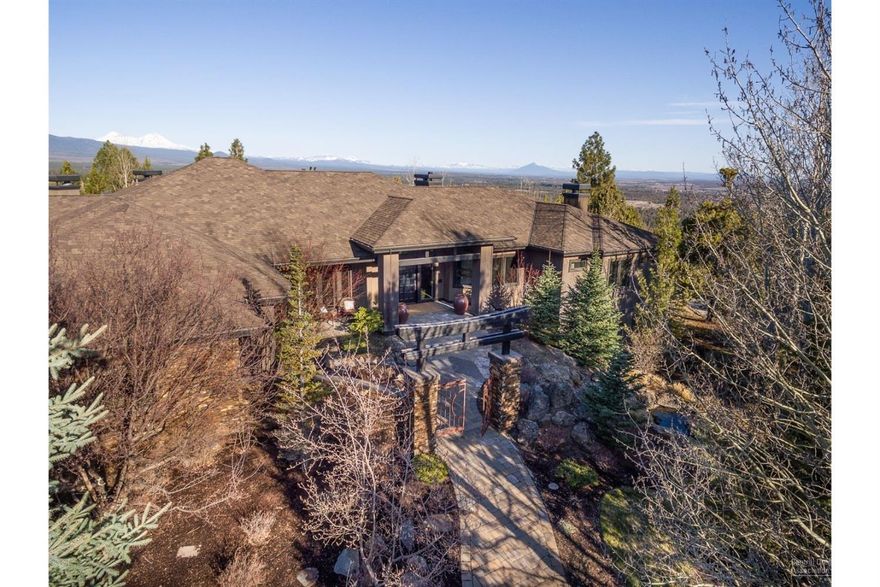 Step into an unprecedented level of luxury not otherwise experienced in Bend, Oregon. This Awbrey Butte home has it all: sweeping Cascade Mountain views, a secluded cul-de-sac location with a flat paver driveway and a grand home to accommodate any group or occasion. Several fireplaces create a cozy and classy ambiance, starting with beautiful living room as you enter the home. Formal and casual dining, as well an outdoor kitchen, wrap-around deck and a large, fenced usable yard complete the indoor-outdoor options. The ample master suite boasts a seating area, fireplace and more of the Cascade Mtn views as seen throughout the home. A great room pulls everyone together with the chef's kitchen with double islands, gorgeous beams on the vaulted ceiling, cozy fireplace seating and casual dining. The lower walk-out level is an entertainer's dream, young or old. A bar, projection screen movie viewing, play space and a fitness/yoga studio also perfect for craft space.