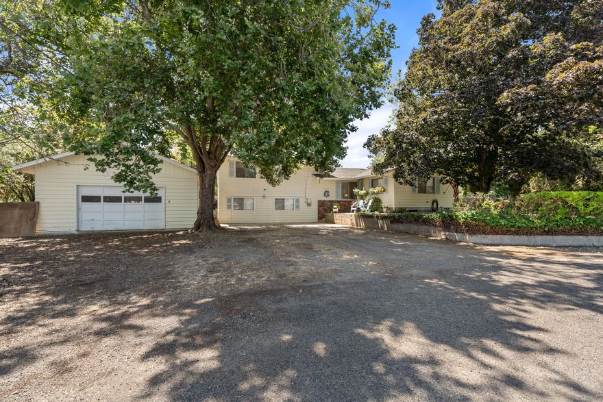 RARE find in Medford! This split level home sits on over half an acre of land! This 2,548 sqft home with a large detached 2 car garage/shop is perfect for your growing family! With 4 bdrms (includes office w/closet), 2 bathrooms and plenty of storage space. The drive-through oversized 748sqft garage/shop allows for plenty of parking for your toys and leads out back to over half an acre of land ready for its next owner to care for. One bedroom is on the main level and two are up the half flight of stairs. The office is on the lower level and there is also a large utility room for storage/office space/etc. The kitchen features beautiful original cabinetry and opens up to the dining room area. Sit back on your deck as you enjoy the sunsets and cool off. This home is located just outside of the official City of Medford limits and has its own well and is on city sewer. The front yard provides ample parking room. Don't wait - Come and tour this home before it sold!