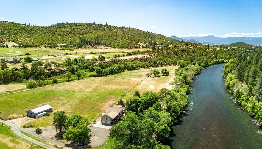 Live in a famous area on the Rogue River w/over 350' of private river frontage & million $$ homes. Beautiful Riverdale custom built home in 2001 w/new updates in 2024! Gated entry w/circle drive. Lg beautiful kitchen w/5 burner gas cook top, dbl wall ovens + warming drawer. New quartz counters, new paint, new carpet and handles. Gorgeous refinished hardwood floors. Lg vaulted ceilings in great rm w/lg wood beam, stone gas log fireplace, floor to ceiling windows over looking parklike grounds. Built in cabinet w/wet bar & wine refrige w/new granite counter. Formal dining w/wainscoting and coffered ceiling. 2 primary suites + lg guest bedrm. Main suite has French doors to deck w/views of the river, vaulted ceilings, lg walk in closet, dbl sinks, jetted tub, lg shower and water closet. 36X60 shop, 5 car garage +workshop area and unfinished basement for storage. Fenced garden area, Hay field w/gravity fed irrigation.