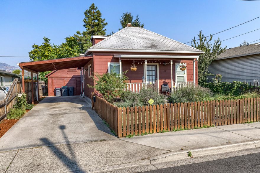 Darling cottage home with attached 2-car carport and detached shop!  Picket fence frames the front yard.  Covered front porch with railing.  Laminate flooring in living and dining rooms.  Updated kitchen offers tile flooring, granite counters, smooth cooktop oven, microwave hood and extra pantry cabinets.  Indoor laundry closet off kitchen.  The bathroom was also updated with granite vanity and tile floor.  Tankless water heater.  Cute and spacious back yard has large patio, lawn and shade trees.  Inground sprinklers front and back.  The detached shop is perfect for projects and/or extra storage!