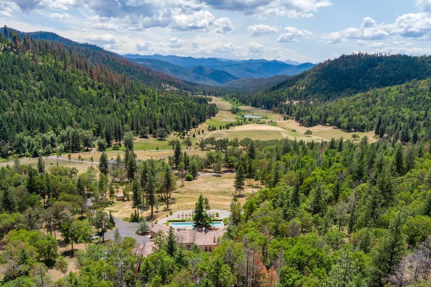 Rural luxury at its best! Designed by a Bay Area architect and custom built by Mike Pagnini, perhaps Southern Oregon's most renowned luxury home builder, this incredible estate offers everything you could dream of in a home of this caliber! Situated on over 22 serene acres in an area of prestigious homes, and bordering BLM, this unique home combines a perfect blend of southwestern flair and mountain lodge oasis. Extensive windows adorn the south side capturing views all the way to northern California. The layout is open and bright with a large island kitchen and spacious master suite. Extras abound including a climate-controlled wine room, geothermal HVAC, exposed timber beams and solid Myrtlewood doors. In addition, the property includes a 575 SF guest house, 75' lap pool, 3 car garage with workshop, 15 x 36 covered RV parking with hookups, V6 propane generator, 8,000 watt solar system, gated and paved drive and more. Once you're here you won't want to leave! Inquire for info packet.