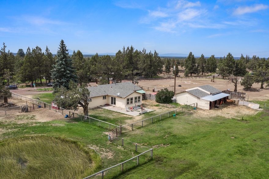 On the west edge of Redmond, 5.2 acres w/2.5 acres of irrigation & single level farm house! Ready for your horses w/4 stalls w/runs, pasture, round pen & complete w/a walk to gallop hot walker. Hay storage, tack room & plenty of storage space. 50 amp hookups for RV, electric car charger too. Spacious home offers dual living spaces & private owner's suite w/great separation. 3 guest rooms & full bath, 1/2 bath off the kitchen. Newer windows & exterior paint, original hardwood floors could be refinished to keep the charm. Home is a blank slate & awaits your finishing touches! Kitchen could be opened up to create a more open feel. Huge family room to accommodate a lg gathering & oversized furniture. Front living room ftrs a real stone surround wood burning fireplace. Located just west of Redmond, minutes to Deschutes River & BLM, airport & easy access to Hwy 126 & 20. Private riding arena available for lg events just down the street. Don't miss - bring your critters & imagination!