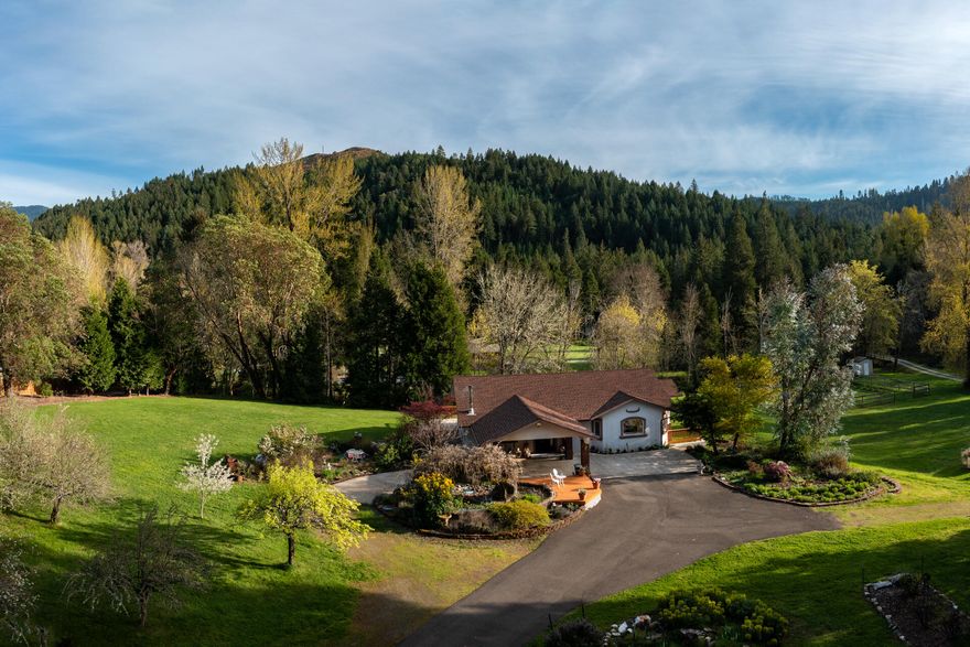 Beautiful, peaceful, quiet, 4.13 Acre retreat w/a 4 bd, 3 bath, 3351 sq ft home. New Roof, decks, sidewalks, & new flooring in 2 rms.   On the main floor, Master w/sitting area, living rm, office, dining rm & Lrg beautiful kitchen w/newer appliances, 5 burner gas top, cherry wood cabinets, Lrg Copper Farmhouse sink, Downstairs are  3 bds with two full baths, Lrg Family rm, & laundry. Lrg windows thru out home w/ mountain views all around.  Year round creek frontage. Rose garden, orchard, fountain, dog kennel, Huge Quonset Hut, 3 car detached garage, 3 stall Barn, Lrg fenced garden area, fenced pasture,  2 separate driveways, Main is a circle paved driveway w/a porte cochere. Sets off the road for privacy. Sidewalks around the home.  2 separate decks upstairs, covered porch areas downstairs.
2 Full RV hookups.
2 sources of heat. Forced Air Propane (1 System upstairs &1 downstair), & Woodstove. High Speed Internet, DFN. Easy Freeway North and South Access.