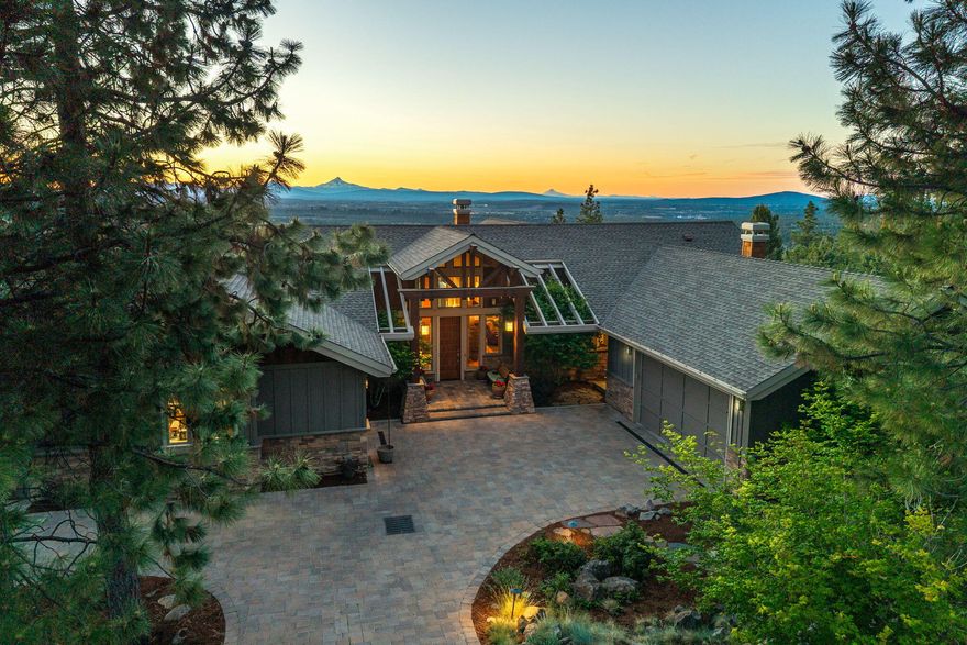 Experience breathtaking views from this extraordinary custom home, perfectly positioned to capture nine Cascade Mountain peaks through expansive west-facing windows. Located in the coveted Awbrey Butte neighborhood of NW Bend, this home offers timeless elegance and stunning scenery. Soaring 20-ft ceilings, oak hardwood floors, a masonry fireplace with reclaimed wood mantel, and architectural windows elevate the main living areas. The chef's kitchen includes Sub-Zero, Dacor, and Bosch appliances, a built-in espresso station, and slab granite. Entertain or unwind on the private view deck with a pergola and retractable sunshades. The lower level features a wet bar, an undercounter fridge, and custom concrete floors. Designed by Don Stevens and offered by the original owner, this home is a showcase of craftsmanship, comfort, and thoughtful detail. Please Note: there is a 3rd bay garage space not showing in floorplan.