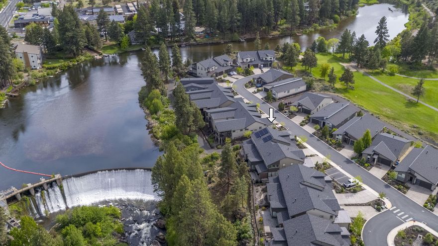 This stunning river front home captures the very essence of Bend living! Stepping into the light filled, welcoming foyer, you pass a main level office and private powder bath before entering the expansive living area. Past the chef's kitchen your eyes are drawn to the dramatic ceiling height. Surrounded by walls of windows, the space is drenched in natural light; providing exquisite views of the river and rushing waterfall! The back patio is the perfect place to host, with views down the river canyon; relax to the sounds of falling water. Retreat inside to the luxurious, main level, primary suite or head up to the expansive great room, complete with wet bar. A second primary suite, guest room and full bath are found here - great privacy for family and guests. The oversized garage is ready for all your toys, with an EV charging outlet and Solar panels to keep you charged up. Peak craftsmanship meets luxury riverfront living here in an exclusive gated community. Come make it yours today