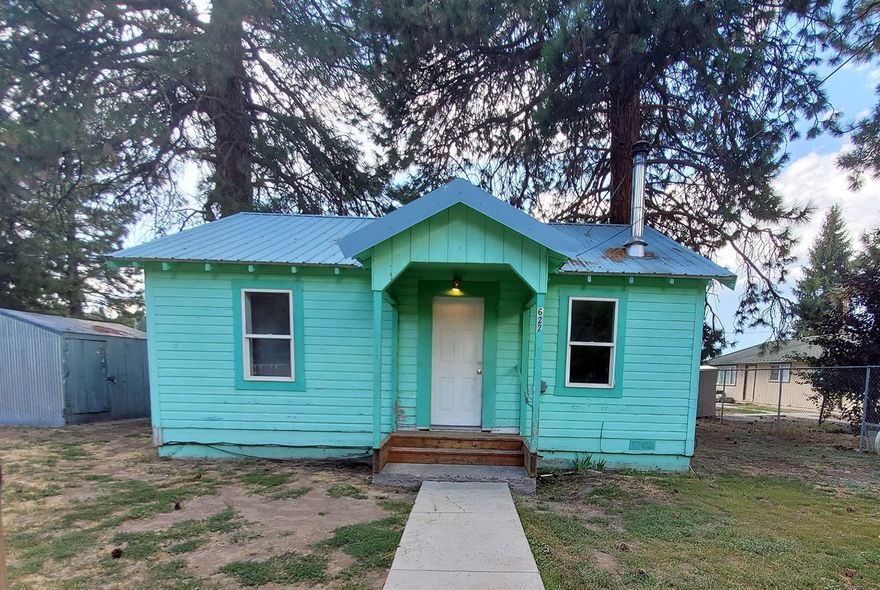 Cute home on fully fenced lot near downtown Chiloquin, Offers good size backyard with two large pines and an alley access. Well insulated with metal roof and vinyl window. Spacious kitchen with room for dining table just off the living room. Wood stove and laminate floor adorn the living room area. Large main bath with exterior door to the side yard and covered porch, makes a perfect mud room. Additional exterior features include a shed, outbuildings, metal roof. Great investment opportunity with exceptional past rental history. Move In Ready.