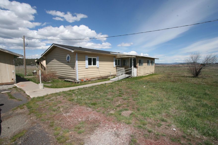 This 3-bedroom, 2-bath manufactured home offers 1,152 square feet of living space and sits on 11.22 acres, providing plenty of room to spread out. Inside, you'll find a nicely sized kitchens, a living room, and a dining area. The home features ramps at both the front and rear entrances for easy access, with the back entrance also offering a covered porch—perfect for enjoying the peaceful setting. Outside, there's a detached garage with multiple storage rooms and a metal hay barn, adding valuable utility to the property. The OC&E Trail is less than a quarter mile away, offering nearby recreation. This is a Small Estate being sold by the Oregon State Treasury Department. ''Sold by the State of Oregon as-is with all know and unknown faults''. This home will not be financeable and will be a cash only sale.