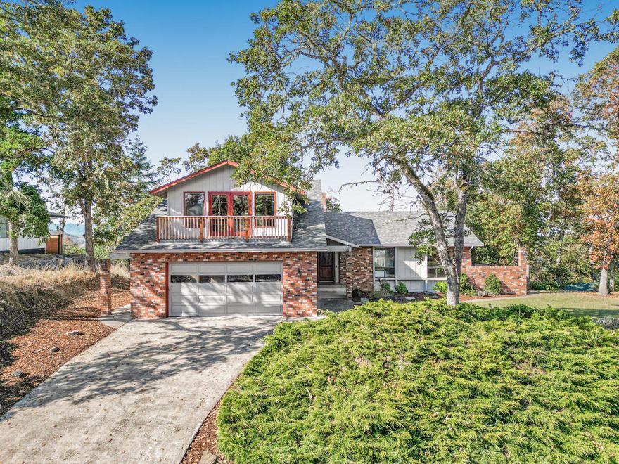 Contemporary-style home on  .49-acre lot overlooking the city! Designed for entertaining, this 3-bedroom, 2.5-bath home has new Myrtlewood flooring throughout living room w/ vaulted wood ceilings, fireplace & sliders to deck w/ stunning city views. Kitchen w/ Corian countertops, large eating nook & c butler's pantry w/ adjacent dining area opening to deck for indoor/outdoor gatherings. Primary suite on main level w/ 440 sq. ft. addition featuring private bath w/  built-in hot tub, tiled shower, dual vanities, dry sauna & 2 walk-in closets. 2 additional bedrooms, full bath & laundry complete main floor. Upstairs is great room w/ French doors to balcony,  kitchenette & half bath providing options as recreation room, media space, guest quarters or home office. Additional highlights include new roof, natural light, & close to restaurants, parks, schools & quick I-5 access. Enjoy exceptional views, privacy & versatile living spaces in this one-of-a-kind city-view home.