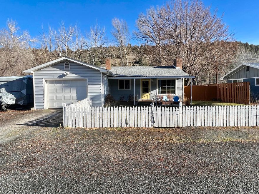 Ready to Move In: Inviting 1956 Ranch-Style House.
Step inside this charming home and relax in the cozy living room complete with a fireplace. Entertain guests in the large dining room and sitting area with exposed brick flooring as well as a wood stove. The kitchen features Formica countertops, and the house includes three bedrooms, two bathrooms, and 1,398 sq ft of living space. Furthermore, original wood floors throughout most of the home are an added bonus. In addition, take advantage of your low-maintenance backyard with access to Canyon Creek. The property is fully fenced and perfect for your four-legged companions.