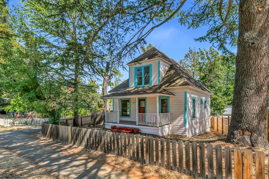 Historic home on a spacious lot with ~121 feet of alley access — centrally located across from Triangle Park! Living and formal dining with high ceilings, curved archways, built-ins, and ceiling fans. Kitchen with tiled counter and backsplash, stainless double sink, refrigerator, and gas range; adjacent informal dining or breakfast nook with built-ins. Main-level bedroom with abundant natural light and second bedroom or office with built-in cabinets and shelving. Full bathroom with pedestal sink and tiled tub shower. Enclosed back porch mudroom with washer and dryer. Two upper-level bedrooms with closets and ceiling fans. Exterior stairs to lower-level basement with poured concrete foundation. Fully fenced yard with mature trees, sunny gardening areas, gated alley access, and large parking area with space for multiple vehicles. Detached 288 SqFt garage with power, storage shelving, and poured concrete slab. Property shall be sold ''As-Is'' in present condition. Inquire for details!