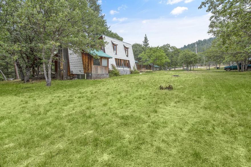 Situated in the sought after Tyler Creek area, this property provides incredible versatility. The main house is a two story 1,492 SF home with two bedrooms and one bathroom. The open living room has great natural light and lots of windows. There is extensive wood detailing throughout the home including hand made windows and stair railing. The kitchen is functional, has a roomy dining room and adjacent sitting area with woodstove. Detached is a 928 SF studio space with loft and full bathroom. It also features a 253 SF attached greenhouse. There are two barns, a corral, a fenced in garden area and plenty of room for animals. There is also a seasonal creek and pond on this property.