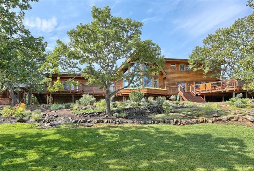 Paradise Awaits in this impressive, close-in, gated Ashland home. In addition to end of the road privacy, there are expansive mountain and territorial views from almost every angle both inside and out. Stunning kitchen with rare rainforest marble countertops, walnut butcher block island w/ breakfast bar, and top of the line appliances. Clerestory windows accent the two-story great room, anchored by a sleek and sophisticated double sided fireplace. Versatile detached workshop, 3 car attached garage, plus a temperature controlled studio w/ sink and adjacent wine cellar. Vaulted, main level master suite w/ cedar-lined walk-in closet. Expansive decks and numerous outdoor entertaining areas including a lush, fern grotto overlooking the land. In addition to a 20'x20' greenhouse, complete with water emitters and automatic vents, there is a fully enclosed organic garden. Irrigation rights, strong well, deer fencing, plus an RV pad.