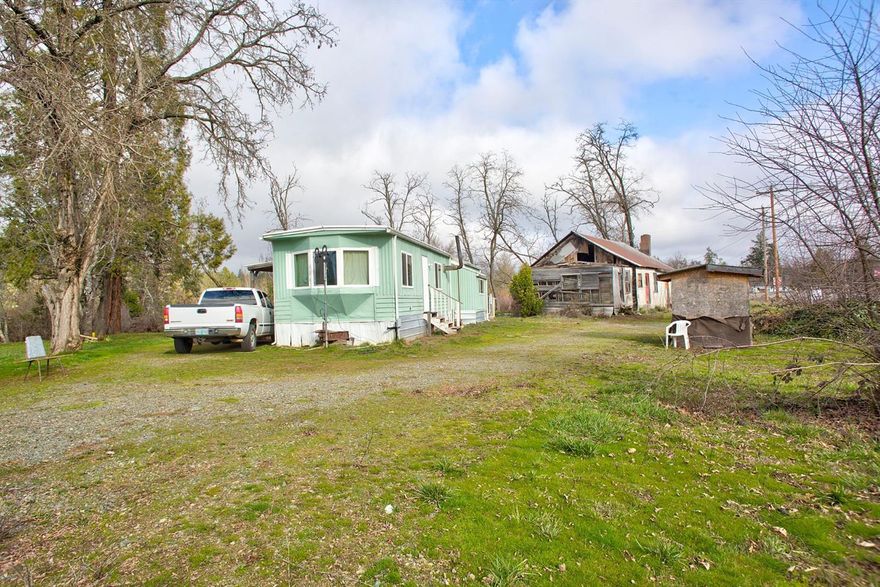 Opportunity in the Illinois Valley! This level 1.20 acre property zoned Rural Commercial is ready for the taking. Prime location for a new business or residence, the choice is yours! 1972 Single Wide features a two bedroom, two bath, 792 square foot split bedroom floorplan with an open kitchen and living room space plus a covered porch overlooking Clear Creek. Additional features include a circle driveway, plenty of room for a garden, a large RV or other toys plus another large structure that with a little fix-up, has endless possibilities! All conveniently located one hour from the majestic redwoods and the Oregon Coast or 30 minutes from Grants Pass and the I-5! Call today!