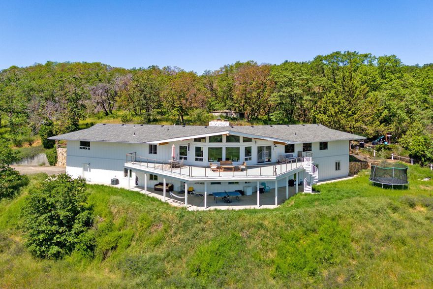 Private estate located in the coveted west hills of southern Oregon; this property offers panoramic views of Rogue Valley. Completely remodeled in 2019, this 6,000+ sf home has two living rooms and a stunning kitchen featuring a 14' granite island and eating bar, equipped w/Wolf 4-burner cooktop with griddle, double ovens, Subzero refrigerator/freezer, butler's pantry, and much more. On 2 levels, with 5 bedrooms, office, bonus rooms, 2 laundry rooms, home theater with five screens and a bar. The primary suite is on the main floor, features a walk-in closet, a huge carrera marble shower w/3 shower heads. The main floor living room has vaulted ceilings with wood beams, flagstone fireplace with gas insert and breathtaking views. This property is entered via a private driveway where one passes by multiple out-buildings: two barns, 3 bdrm/2 bath, 1,782 sf rental property. 2 wells and a 10K gallon holding tank. If you have been looking for something truly special, this is it.