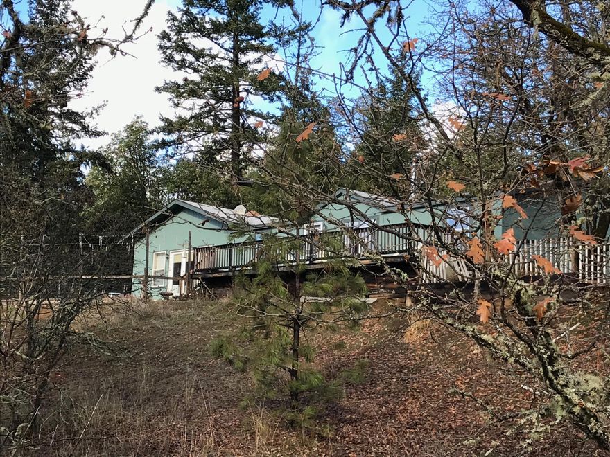 Inviting & charming! This 4 bd/2 1/2 ba, 1800 sq ft manufactured home is situated on an ideally southern facing &  gently rolling 3.04 acres in a great and private Applegate location. The house is nestled at the back of the property up away from the neighborhood lane, featuring a spectacular view of Greyback Mountain which is centered in the 180 degree panoramic view with virtually no other neighbors homes visible! WOW! This home features a split floor plan with the master bdrm & ba on one side of the home & on the other side of the home another bdrm & full ba. There are 2 bdrms in the center with an additional 1/2 ba. A beautiful newer wood laminate flooring is present throughout the home. There are 2 certified Quadra Fire wood stoves, one in the living room opposite the kitchen, the other in the oversized roughly 24' x 12' family room at the back of the house. The family room has French doors leading out to a south facing established organic garden w/3-8' x 4' raise beds.