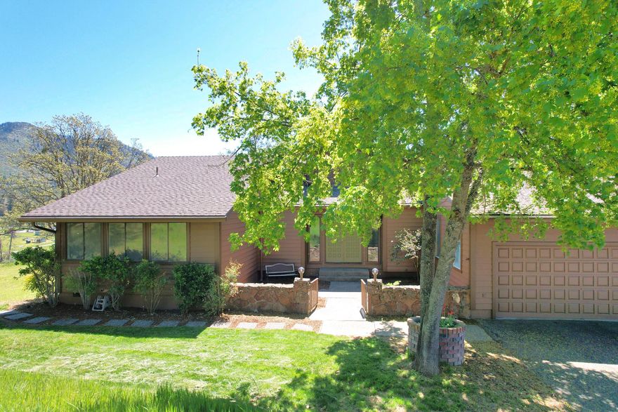 Vast Views & Country Community! This home captures breathtaking valley views that would inspire any folk-art enthusiast w/ scenes of children at play, farmers tending their fields & snow-capped mountains. Well-built custom home, ready for your updates.  Stunning living room featuring a full wall of windows & a grand rock fireplace w/ warmth & rustic elegance. Functional & cozy kitchen w/ island & a wood stove. Master suite offering expansive southern views & access to the sun-drenched patio & gazebo. Living room & dining area also open up to this beautiful outdoor space, ideal for relaxing or entertaining. 2 spacious guest bds & bath layout that separates facilities for added privacy & convenience. Mostly forested 5 acres, home is perched on a large knoll w/ a 1152 sq.ft. metal shop w/ 200 amp, ideal for hobbies, storage & projects. Plenty of room for RVs & outdoor toys. This is the easy, peaceful lifestyle you've been looking for.