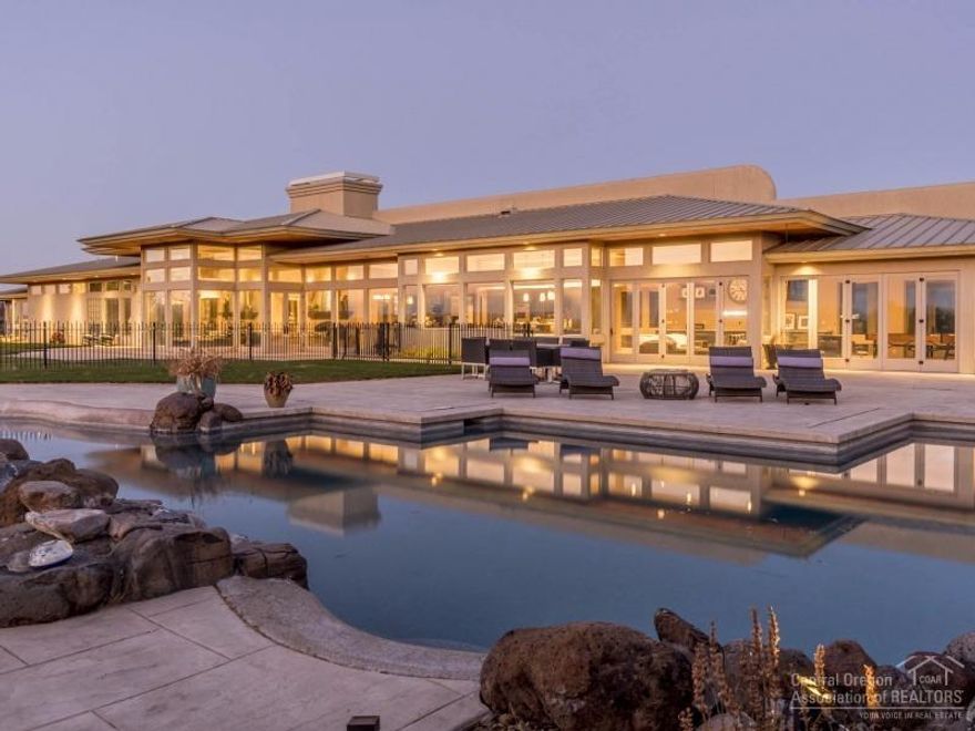 Exquisitely Remodeled Estate just minutes from Bend on 25 acres. This single level estate is 7320 sq ft with soaring windows & breathtaking views of the Cascades. Includes formal & casual living with Cascade mountain views from every room, extraordinary finishes throughout, 5 master suites, theater room, large private office, gym, heated floors & triple car garage. Outside enjoy the Pebble Tieck pool, 7 water falls, hot tub and fire pit for hours of entertaining. Fully insulated 6 Car Shop & gated driveway.