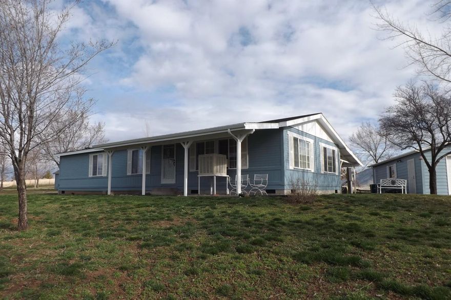 Small Acreage! This MH is in excellent condition. This 3 bedroom, 2 bath home has Fresh exterior paint, sidewalks, large covered patio, Detached Heated Garage/Shop & Carport that has 220 and includes an Air compressor and Welder. Walnut, Peach, Apple & Plum tress. EID irrigation. All of this on 3.06 acres with a view!